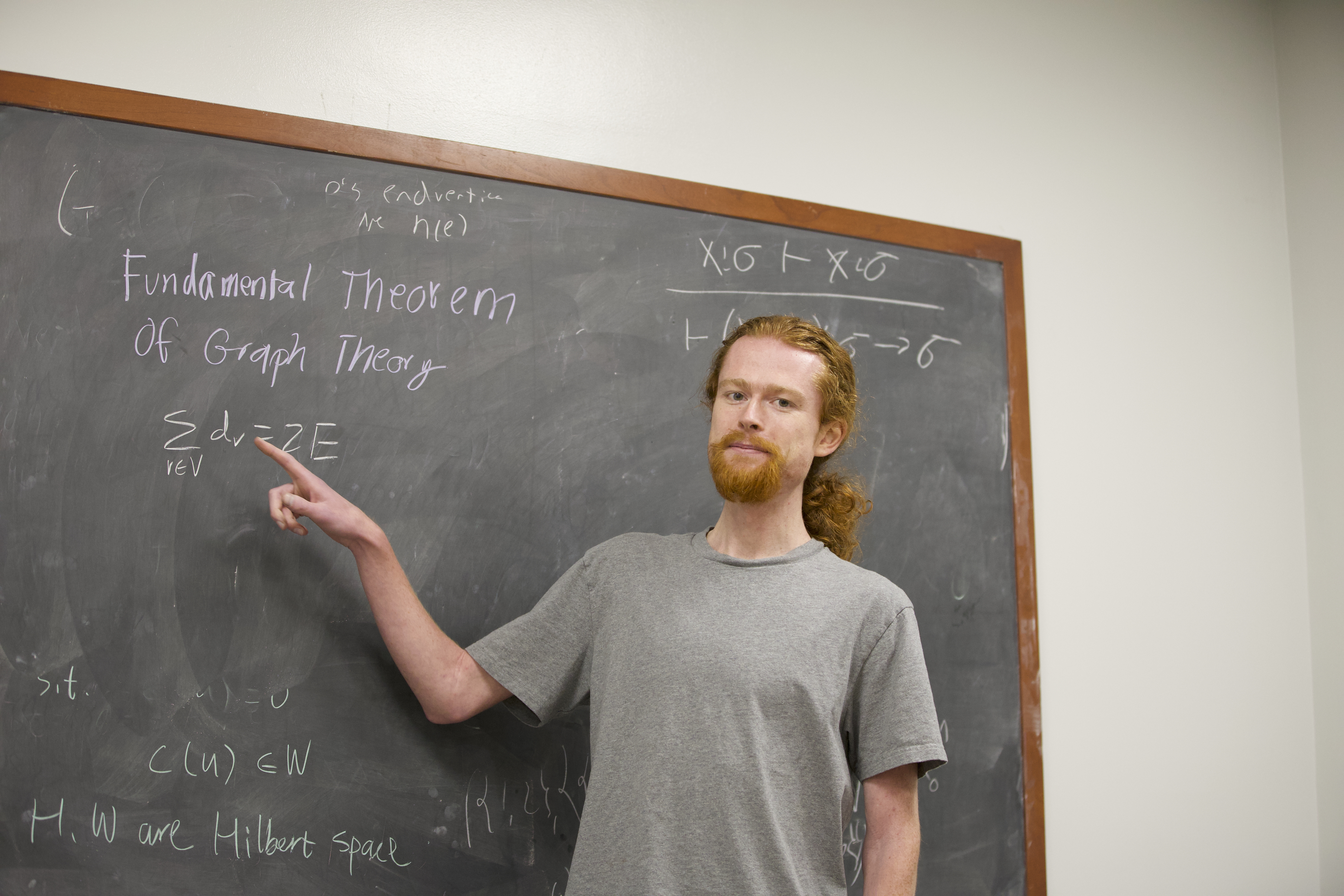 image of Isaiah pointing to the handshaking lemma on a blackboard